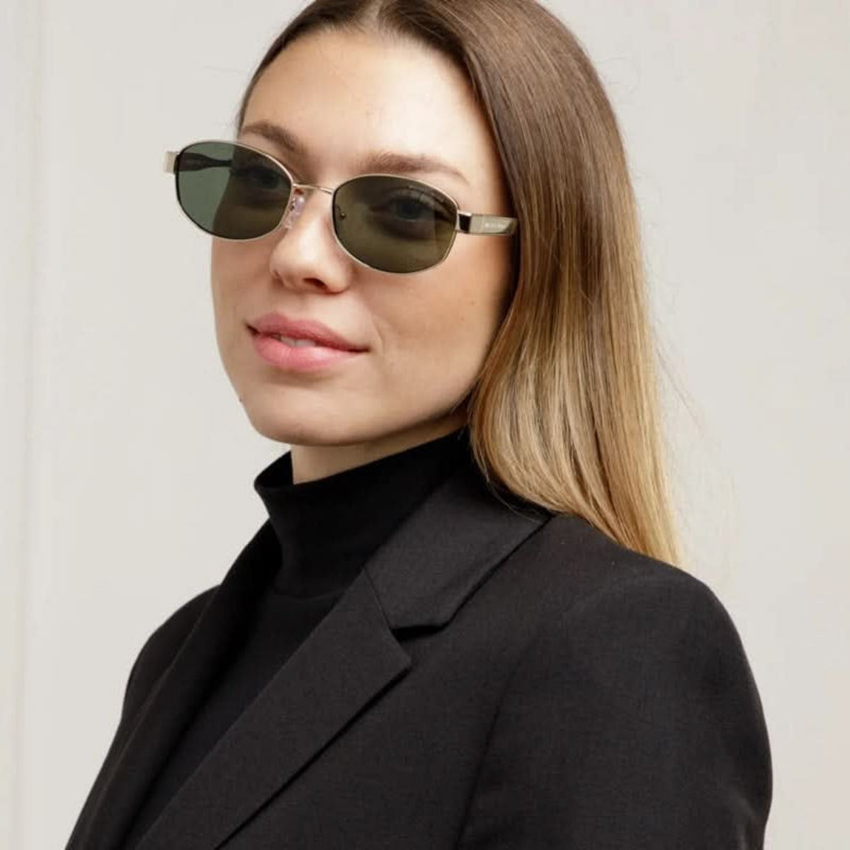 Woman wearing Michael Kors MK1161 light gold oval sunglasses, another view